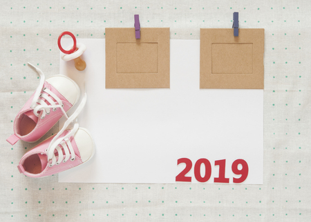 Cute little baby shoes on green polka dot background, top viewの写真素材