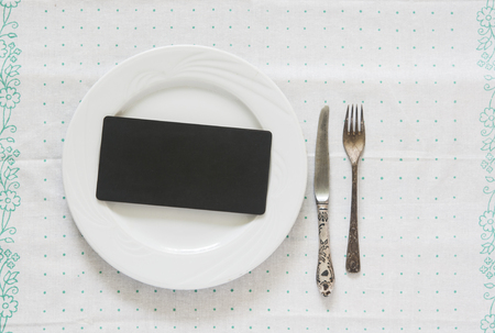 White empty plate with vintage silver ware fork and knife on a polka dot tableclothの写真素材