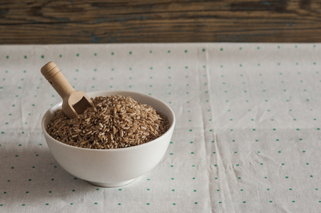 uncooked spelt grain (dinkel wheat) in white bowlの写真素材