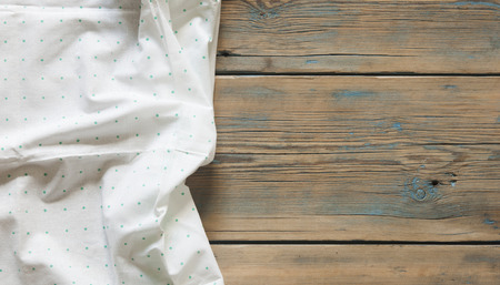 polka dot tablecloth or towel over the surface of a brown wooden tableの写真素材