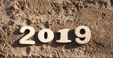 Close up of new year texture 2019 on sand background.
