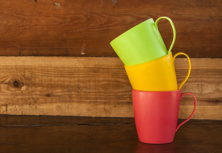 stack of colorful coffee cups on a old  wooden backgroundの写真素材