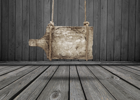 Old wooden banner hanging on a dark grungy room and copy spaceの写真素材