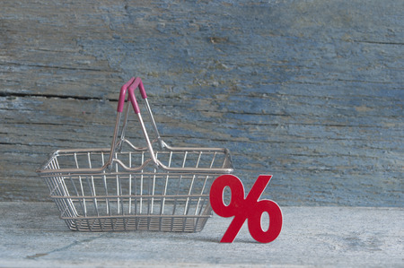 Shopping cart and sign percent with sale concept on wood backgroundの写真素材