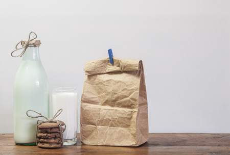 Glass of milk and chocolate chip cookies on wooden backgroundの写真素材