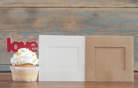 Text love and cupcake with heart shapes on wooden backgroundの写真素材