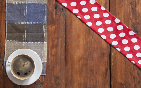 White cup of coffee with colorful napkin on old wooden table. Top view point.の写真素材