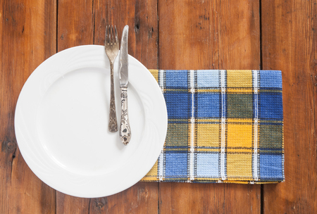 Rustic table setting with cutlery and colorful napkin on dark wooden table. Space for text, top view.の写真素材