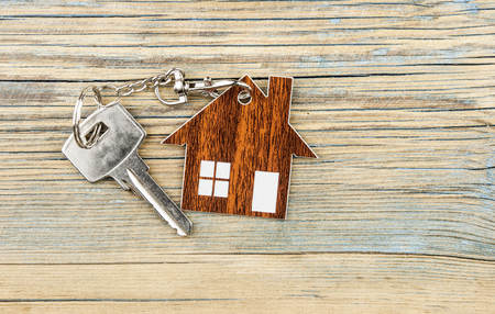 Symbol of the house with silver key on vintage wooden backgroundの写真素材