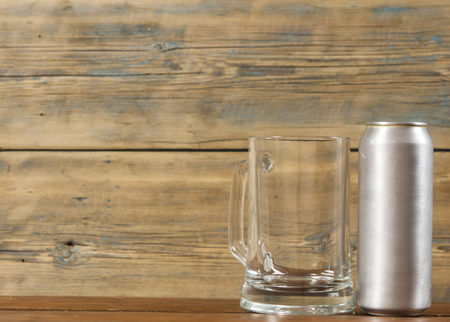 metallic can and glass blank mug of beer on a wooden backgroundの写真素材
