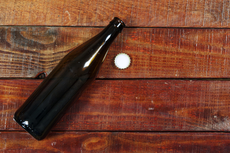 Top view of near empty bottle and cap on rustic wood background.の写真素材