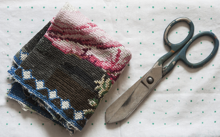 Colorful threads and old scissors on polka dot background. Old sewing accessories