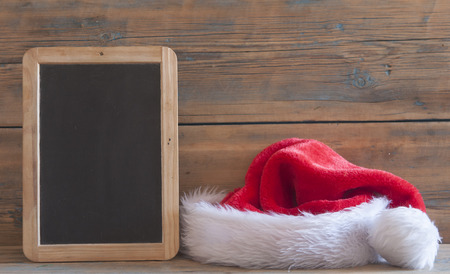 Santa Claus hat with Christmas decoration on wooden tableの写真素材