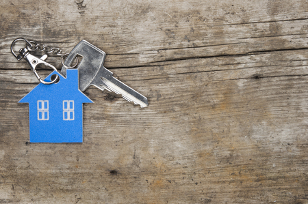 Symbol of the house with silver key on vintage wooden backgroundの写真素材