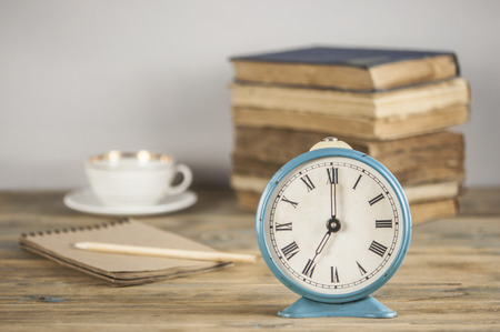 Concept education student and reading book.Wake up Alarm clock 7.00 and reading book on wood table