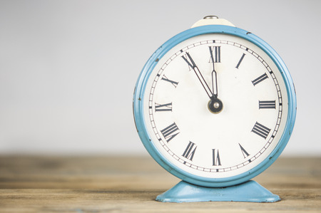 Retro vintage alarm clock on wood table, time concept idea.の写真素材