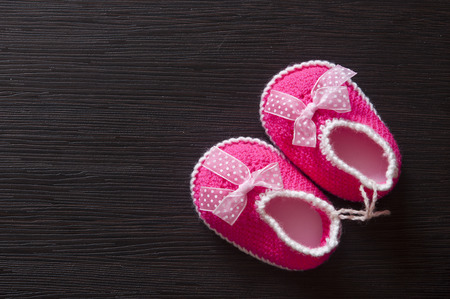 Baby girl shoes on wooden background, banner, copy space, top viewの写真素材