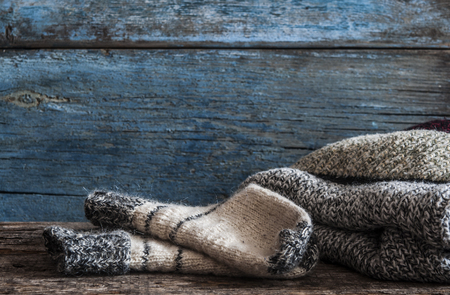 Knitted handmade wool socks on wooden boards close-upの写真素材