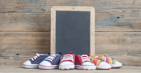 colorful shoes for a small baby on a wooden background.の写真素材