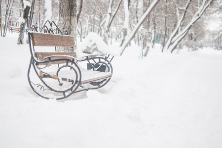 bench in the park in the snow in winterの写真素材