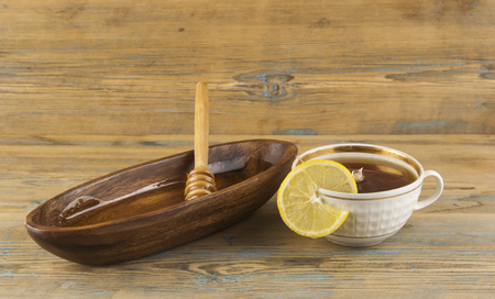 Cup of tea with lemon and honey on wooden backgroundの写真素材