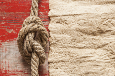 Nautical background with old paper or parchment or map and a rope with a sailor's knotの写真素材
