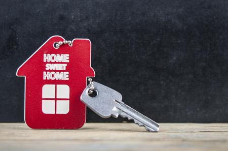 House symbol with silver keys on wood. Real estate conceptの写真素材