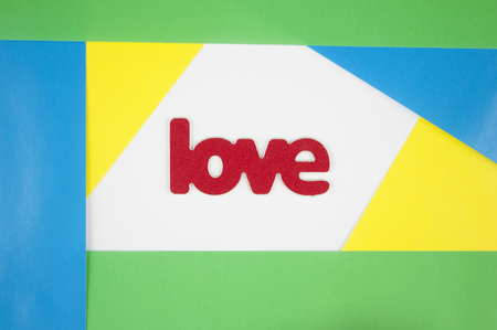 colorful paper background with word "love". Valentines day card with copy space, top view. Love and relationship concept.の写真素材