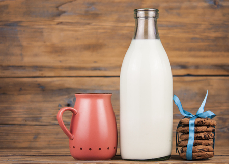 A stack of cookies with bottle of milk, pink mug  on wooden background.Village Breakfastの写真素材