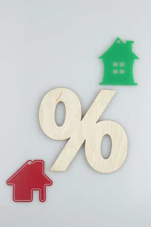 Relocation and house hunting concept. Model of wooden house with sign percent on white background. Top Viewの写真素材