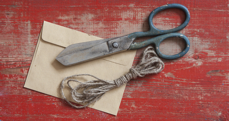 Tools and components for DIY self-made envelope for letters on a wooden surface. Scissors, paper, cord.の写真素材