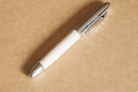 Fountain writing pen lie on brown paper backgroundの写真素材