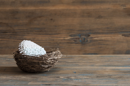 Colorful easter cookies in nest on wooden backgroundの写真素材