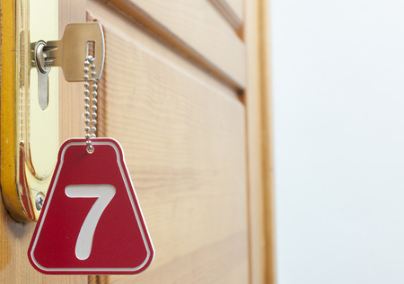 Door wood and key in keyhole with numbered labelの写真素材