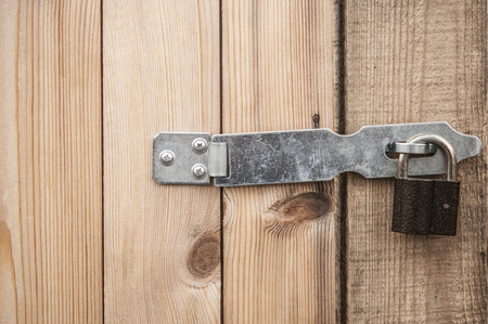 rusty padlock on the bolt, the old dilapidated boards