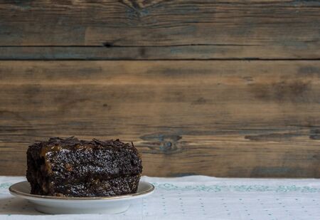 plain chocolate brownie in white plate on wooden plankの写真素材