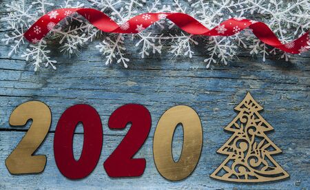 New year concept - Number 2020 for New Year and decoration on a wooden table. With vintage styled...