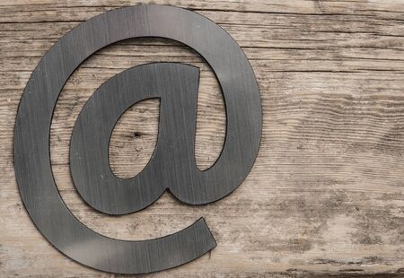 silver email symbol on wood textureの写真素材
