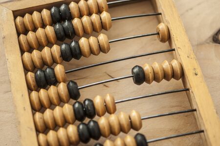 Old wooden abacus on a wood background. Calculating frame. Old scores or calculator.