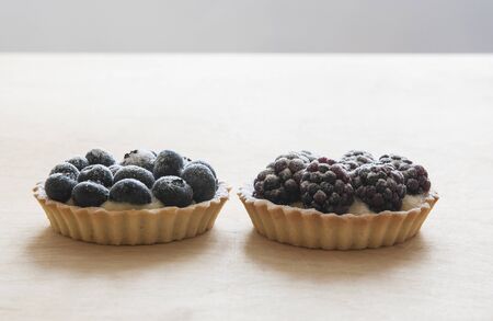 fruit tartlet on the wooden table, fruit baked shell, fruit cupcake with berryの写真素材