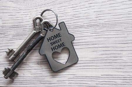 Key house with tag text home sweet home on wood background.の写真素材