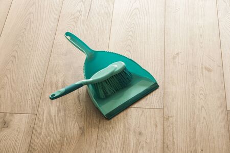 Scoop and brush green cleaning kit on hardwoodの写真素材