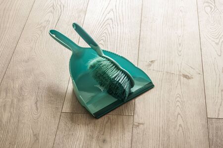 Scoop and brush green cleaning kit on hardwoodの写真素材