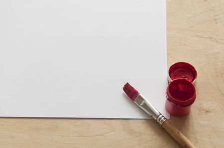 Blank piece of paper with brushes and watercolors on kid's desk, top view with copy spaceの写真素材