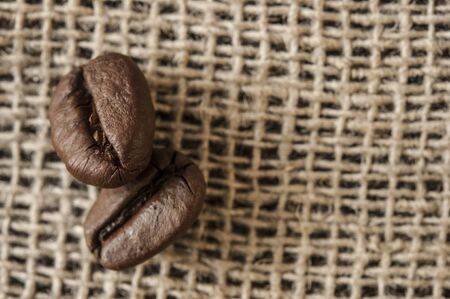 Brown coffee beans is on the burlap sack background.の写真素材