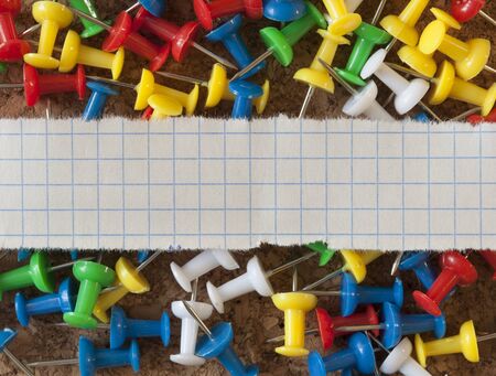 Group of colorful push pins on cork bulletin board