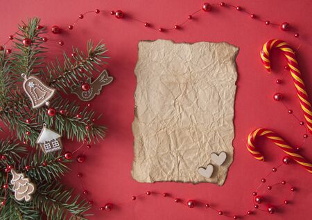 Christmas composition. Fir tree branches and decorations on red lay, top view, copy spaceの写真素材