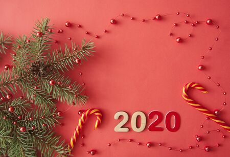 Christmas composition. Fir tree branches and decorations on red lay, top view, copy spaceの写真素材