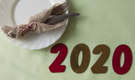 festive table setting, Christmas dinner lunch. White plate, fork and knife in napkin. Top view, copy space. Table setting, background for menu, layout.の写真素材