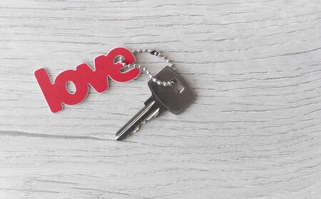 the word love has red lettering on a background  wood, heart and keys